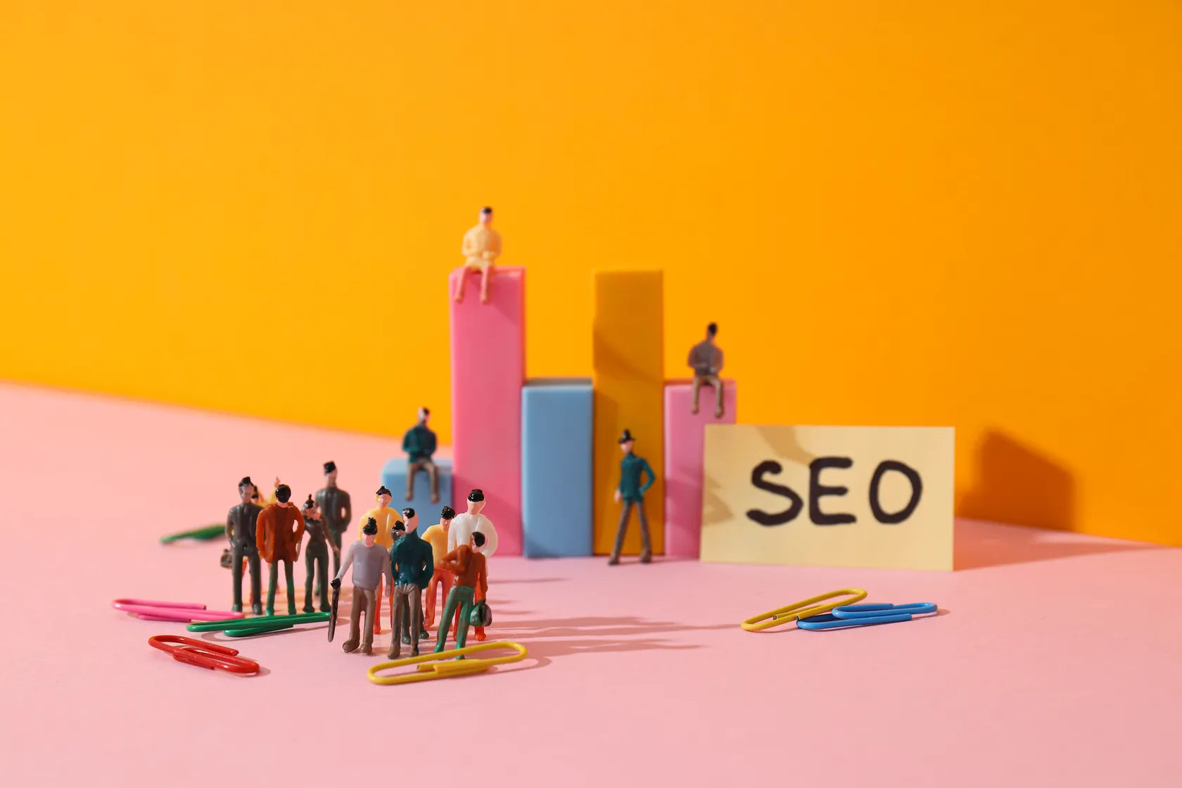 Gráfico de barras con figuras y un cartel de SEO que representa la elección entre agencia y consultor SEO